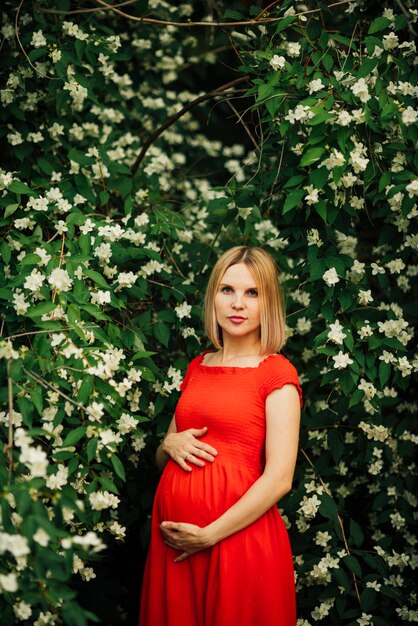 Retrato de plano medio de mujer embarazada con flores.