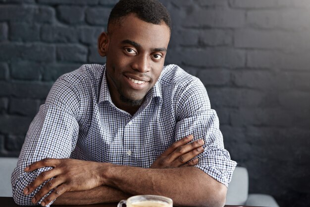 Retrato de primer plano del apuesto joven empresario feliz en camisa a cuadros