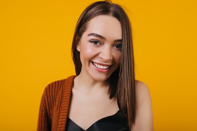 Retrato de primer plano de chica morena emocionada aislada. Mujer joven de ojos marrones con cabello lacio riendo