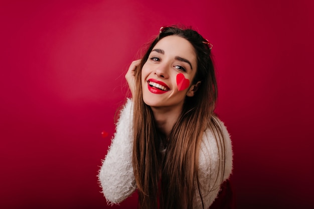 Retrato de primer plano de dama elegante con cabello oscuro jugando en el día de San Valentín