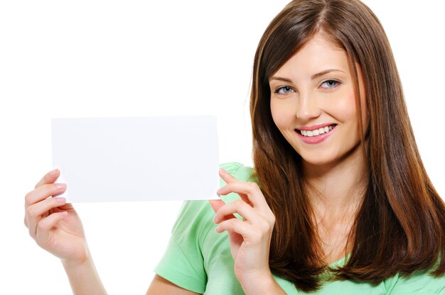 Retrato de primer plano de feliz joven hermosa mujer sosteniendo en manos tarjeta en blanco blanco