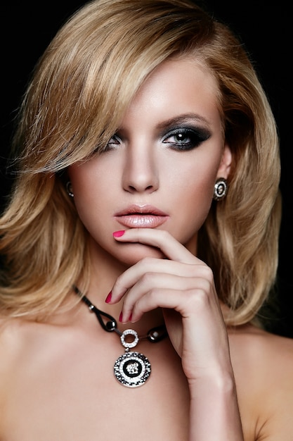 Retrato de primer plano de glamour de hermosa sexy caucásica rubia joven modelo con maquillaje brillante