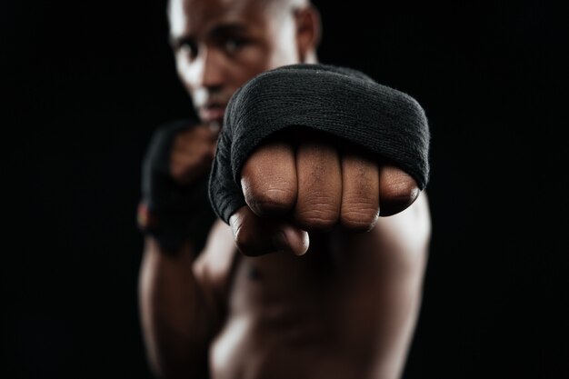 Retrato de primer plano del joven boxeador afroamericano, mostrando sus puños