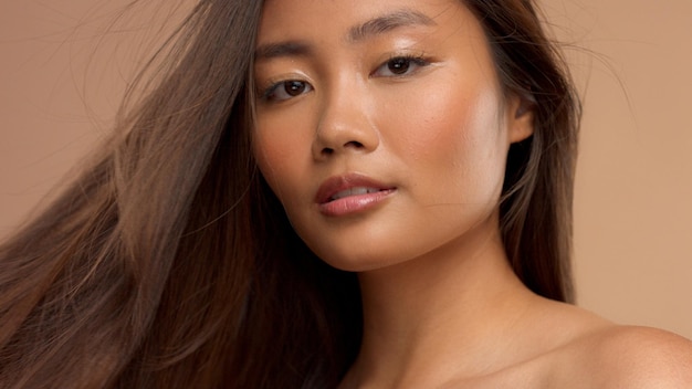 Retrato de primer plano de la modelo japonesa tailandesa asiática con el pelo lacio ideal que sopla