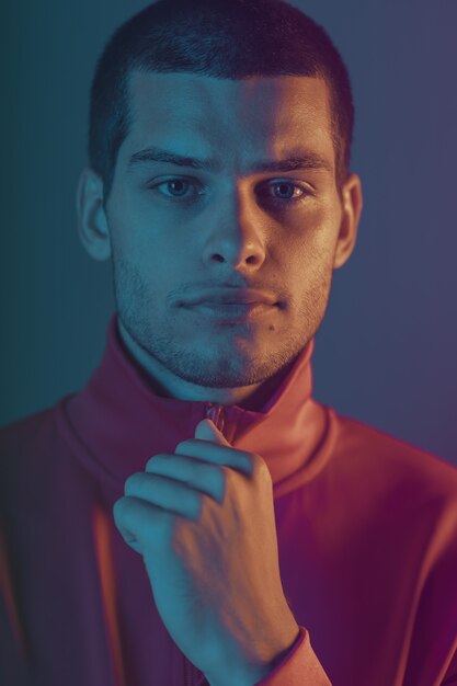 Retrato de primer plano de modelo masculino atractivo. Luz de flash de color