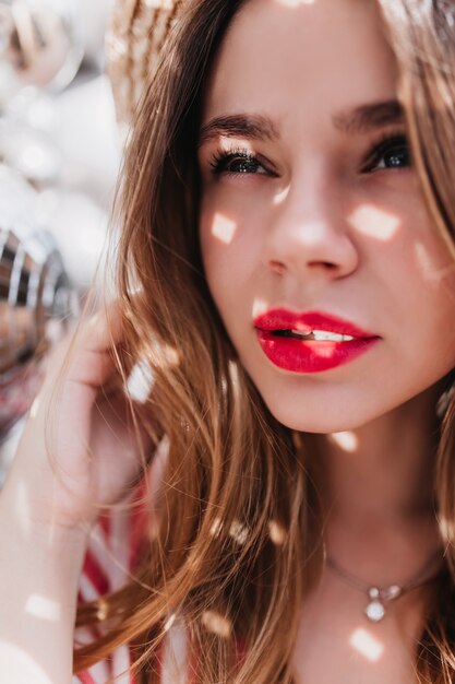 Retrato de primer plano de mujer caucásica sensual con labios rosados brillantes. Foto de chica atractiva pensativa con cabello rubio.