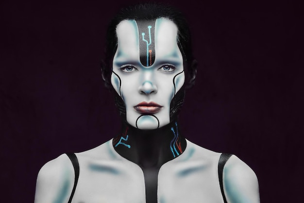 Retrato de primer plano de una mujer cibernética con maquillaje creativo posando sobre un fondo de textura oscura. Tecnología y concepto de futuro.