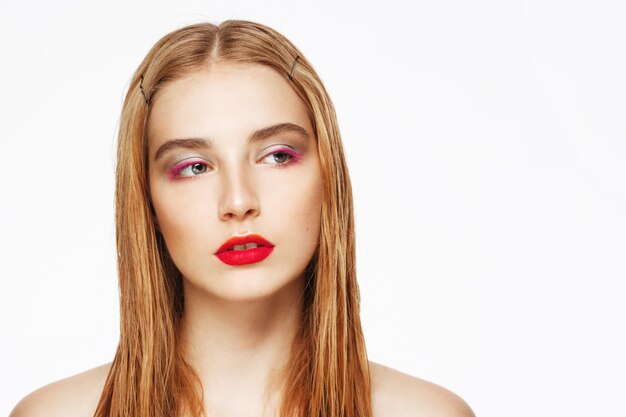 Retrato de primer plano de mujer joven confiada con maquillaje brillante.