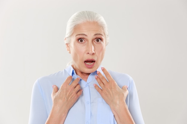 Retrato de primer plano de mujer madura sorprendida en camisa azul