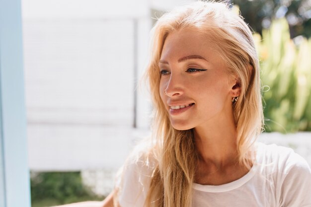 Retrato de primer plano de niña con piel ligeramente bronceada. Foto de glamorosa mujer rubia sonriendo