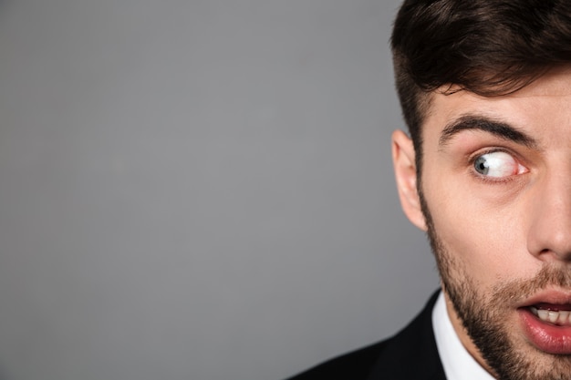 Retrato recortado asustado joven barbudo mirando a un lado