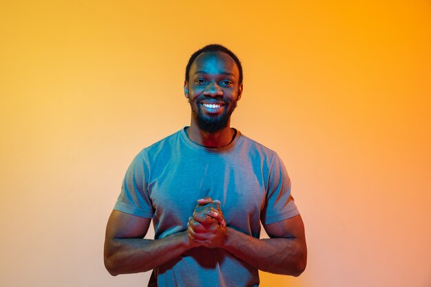 El retrato retro de la onda o de la onda del sintetizador de un hombre africano serio feliz joven en el estudio.