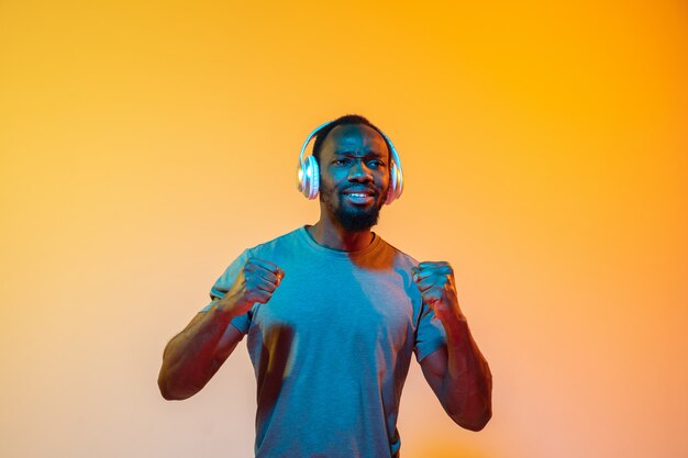 El retrato retro de la onda o de la onda del sintetizador de un hombre africano serio feliz joven en el estudio.