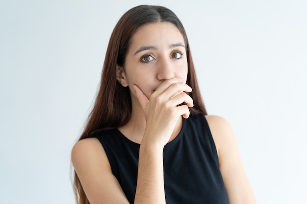 Retrato de la risa de la mujer joven que cubre la boca con la mano