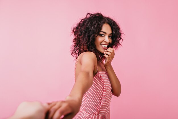 Retrato romántico de linda chica amigable con sonrisa blanca como la nieve. Modelo bronceado posando