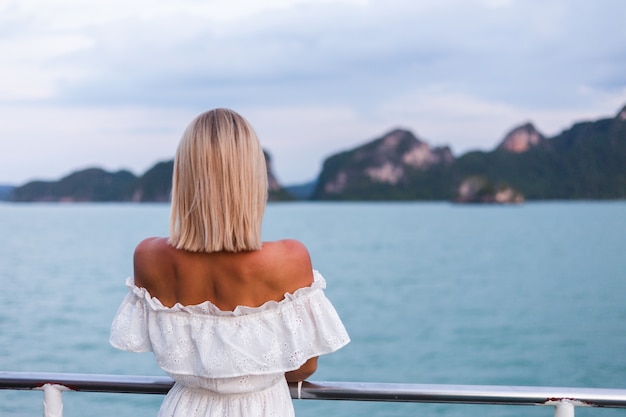 Retrato romántico de mujer en vestido blanco navegando en ferry grande