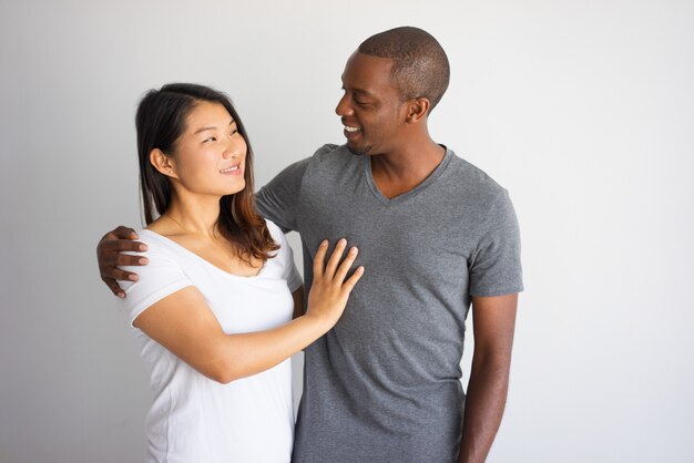 Retrato romántico de pareja interracial sonriendo el uno al otro.