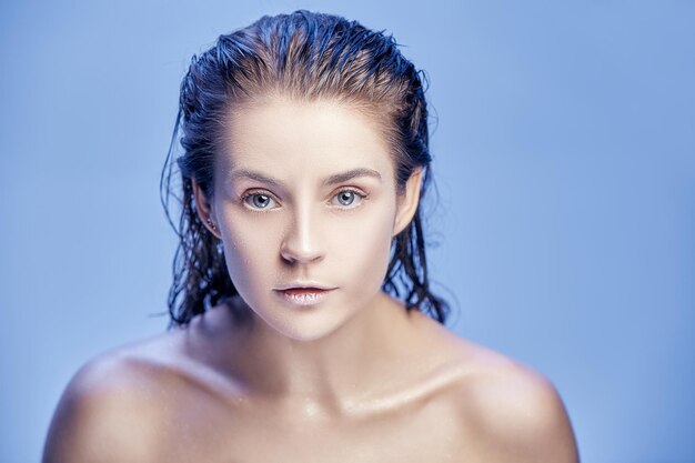 Retrato de rostro de mujer hermosa de cerca sobre fondo azul