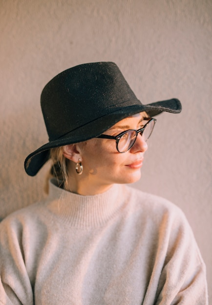 Foto gratuita retrato, de, un, rubio, mujer joven, llevando, negro, lentes, y, sombrero