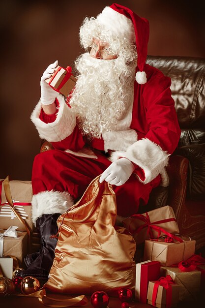 Retrato de Santa Claus en traje rojo con caja de regalo