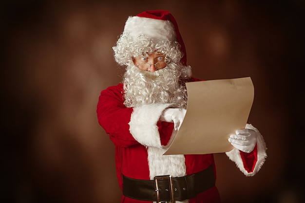 Retrato de Santa Claus en traje rojo leyendo una carta