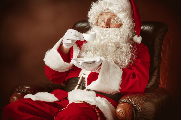 Retrato de Santa Claus en traje rojo con taza de café