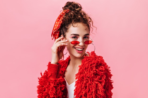 Retrato de señora bonita en chaqueta roja y elegantes anteojos