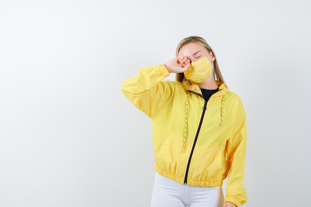 Foto gratuita retrato de señorita frotándose los ojos en chaqueta, pantalón, máscara y mirando soñoliento vista frontal