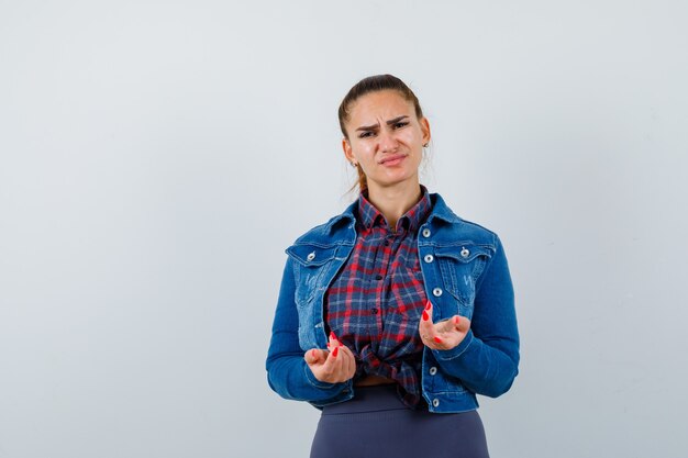 Retrato de señorita mostrando gesto despistado en camisa, chaqueta y mirando decepcionado vista frontal