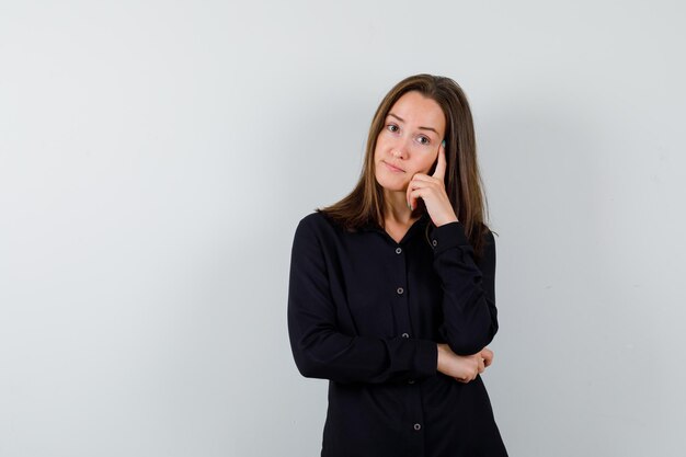 Retrato de señorita de pie en pose de pensamiento