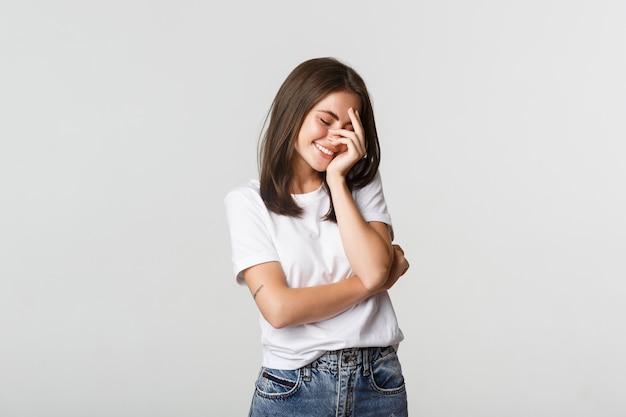 Retrato de sensual hermosa chica morena coqueta sonriendo y ruborizándose.