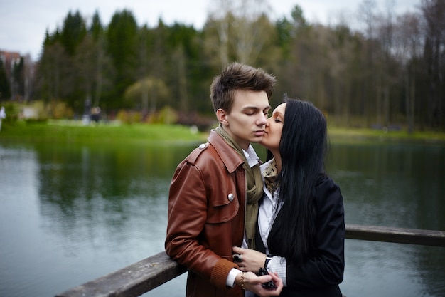 Retrato sensual de la hermosa pareja de moda romántica de pie en el parque.Muchacha morena