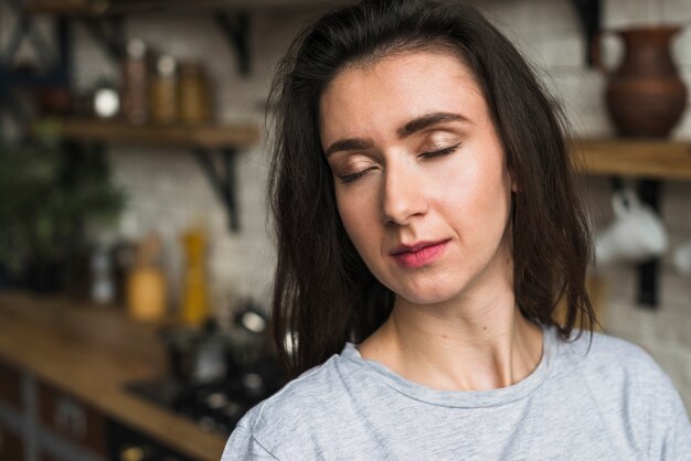 Retrato de una sensual mujer lesbiana de pie en la cocina