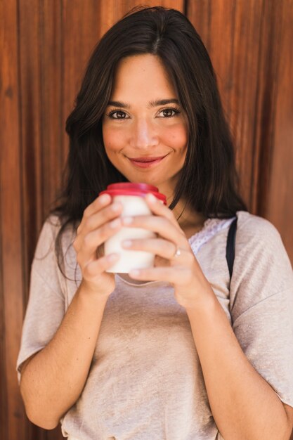 El retrato sonriente de una explotación agrícola de la muchacha se lleva la taza de café