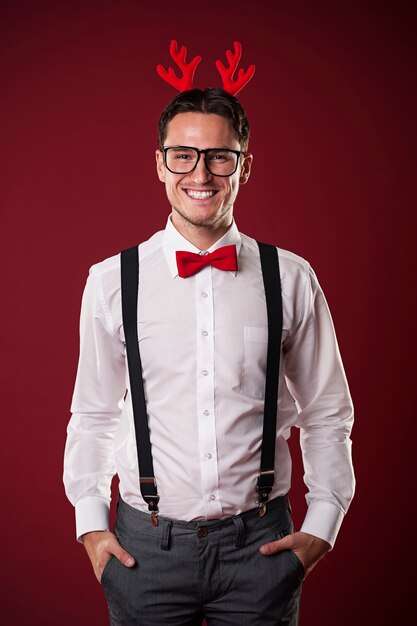 Retrato de sonriente hombre nerd con cuernos de Navidad