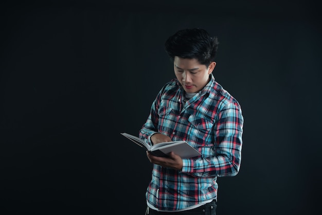 Retrato de sonriente joven estudiante universitario con libros