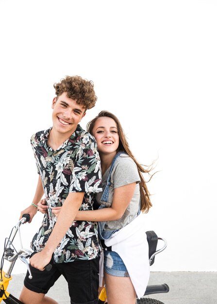 Retrato de sonriente joven pareja disfrutando el paseo en bicicleta