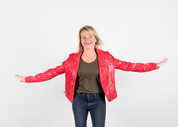 Retrato sonriente de una mujer elegante en chaqueta de cuero roja contra el fondo blanco