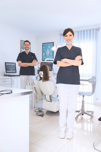 Retrato de sonriente mujer y hombre dentista en clínica