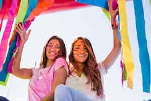 Foto gratuita retrato sonriente de una mujer joven con color holi en su cara mirando a cámara