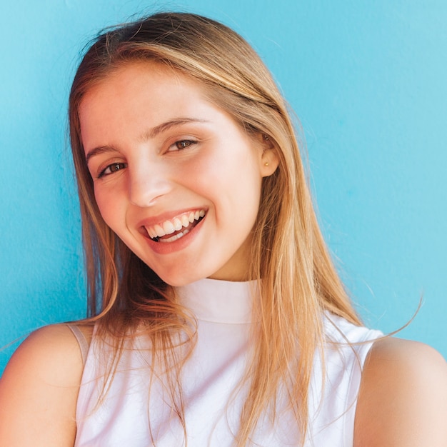 Retrato sonriente de una mujer joven hermosa que mira la cámara