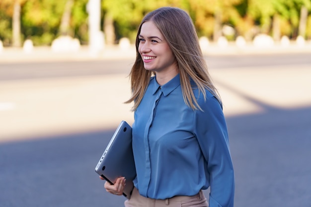 Retrato sonriente de mujer joven rubia con camisa azul suave