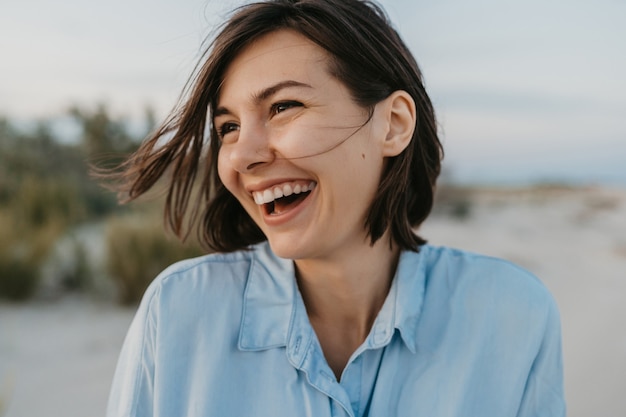 Foto gratuita retrato sonriente de mujer riendo sincera en la playa