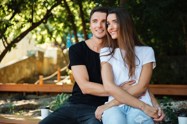 Retrato de una sonriente pareja atractiva en amor sentado