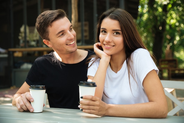 Retrato de una sonriente pareja feliz bebiendo café