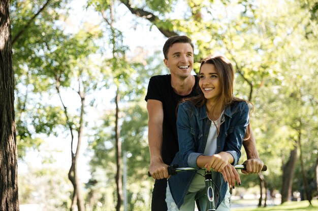 Retrato de una sonriente pareja feliz montando en bicicleta