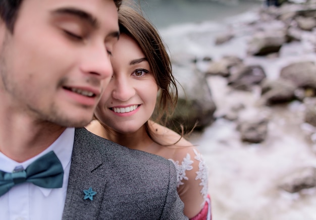 Foto gratuita retrato de la sonrisa pareja caucásica, niño y niña morena vestida con vestimenta oficial al aire libre