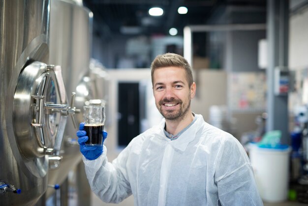Retrato de tecnólogo probando la calidad del producto en la planta de producción de bebidas alcohólicas