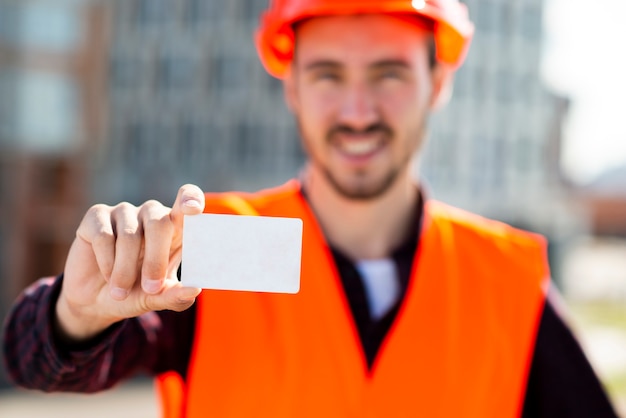 Foto gratuita retrato del tiro medio del ingeniero de construcción que sostiene la tarjeta de visita