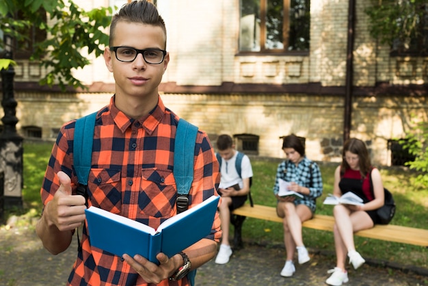 Retrato de tiro medio de niño de escuela secundaria con libro abierto